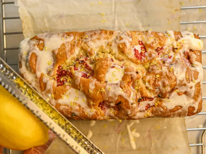 keto raspberry bread with lemon being zested on top