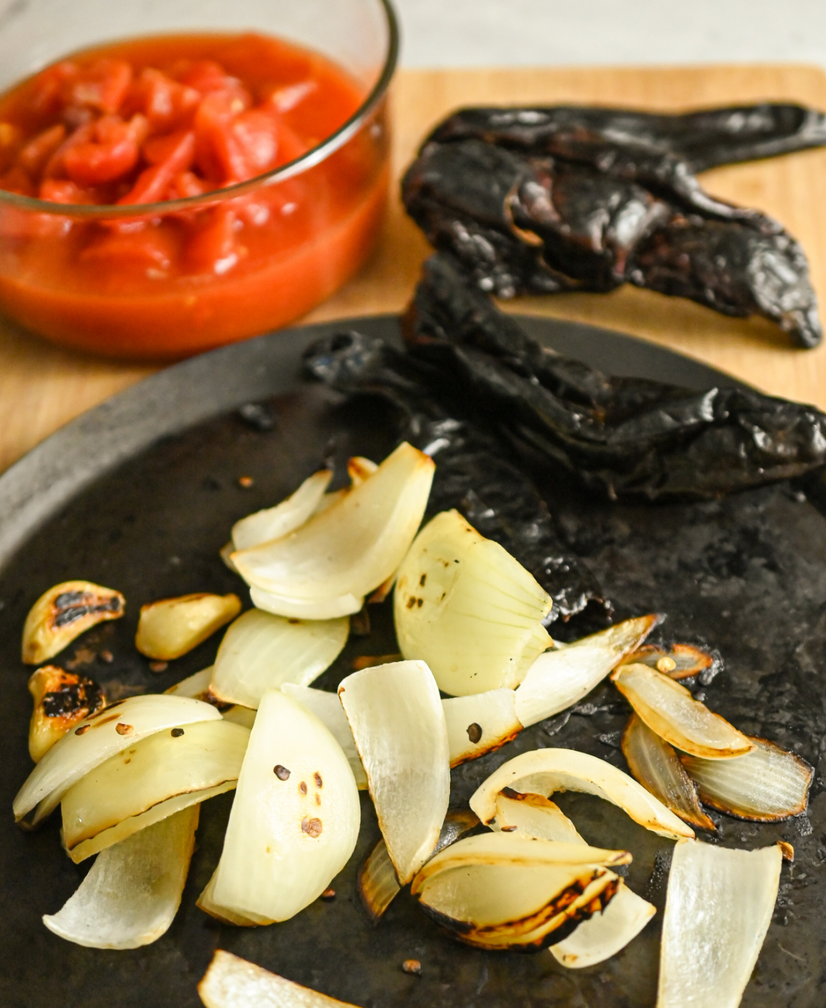 roasting dried peppers along with garlic and onion on a comal