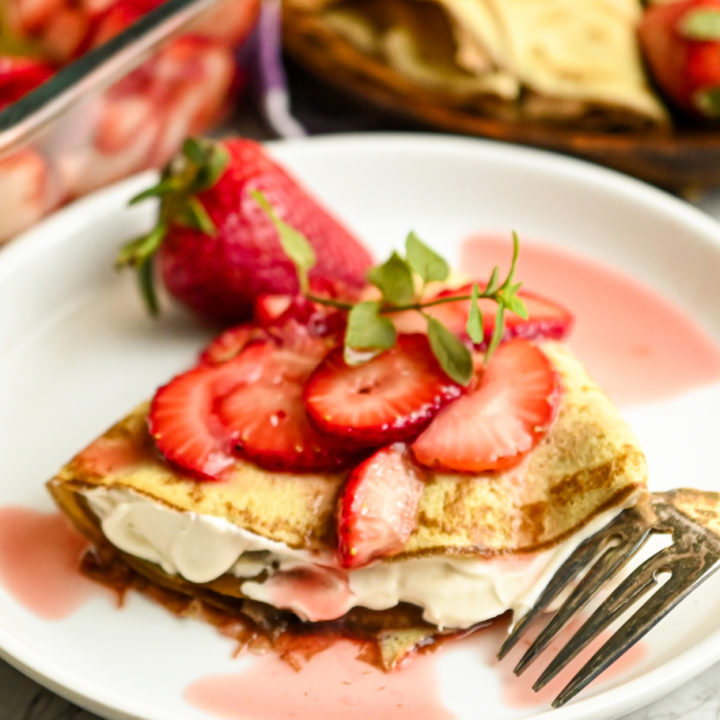 keto Crepini strawberry cream cheese crepe on a white round plate