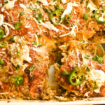 Keto green chicken enchiladas being served from a white baking dish