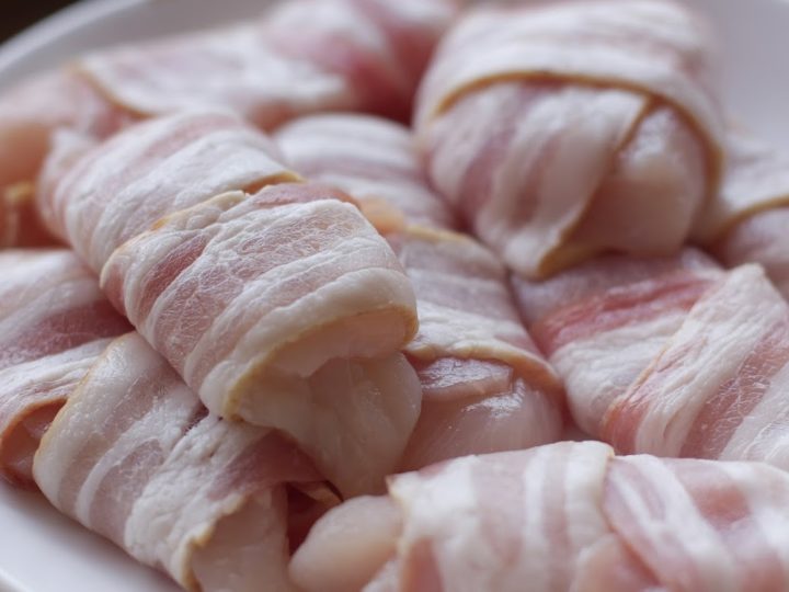 bacon wrapped chicken pieces on a white plate (