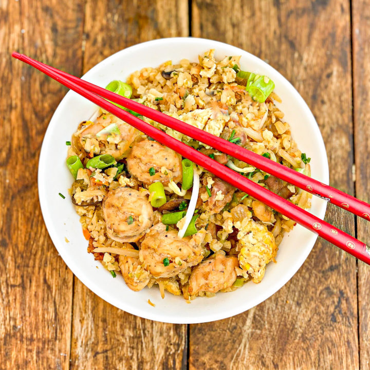 cauliflower rice chicken fried rice served in a white bowl