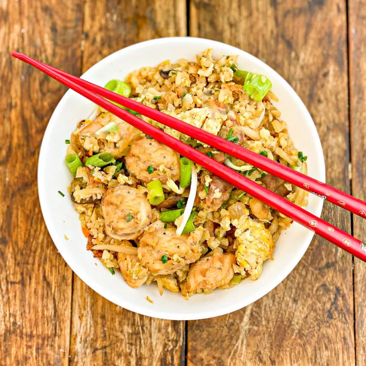 cauliflower rice chicken fried rice served in a white bowl