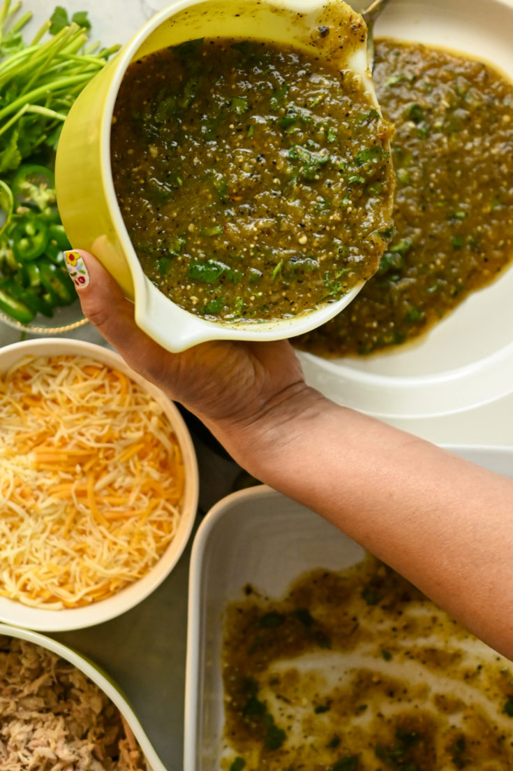 homemade green enchilada sauce being poured from a green pyrex