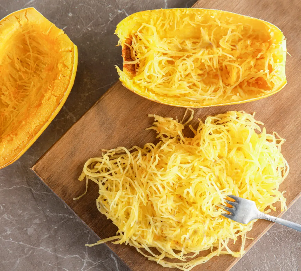 spaghetti squash sliced with a fork making it into strands