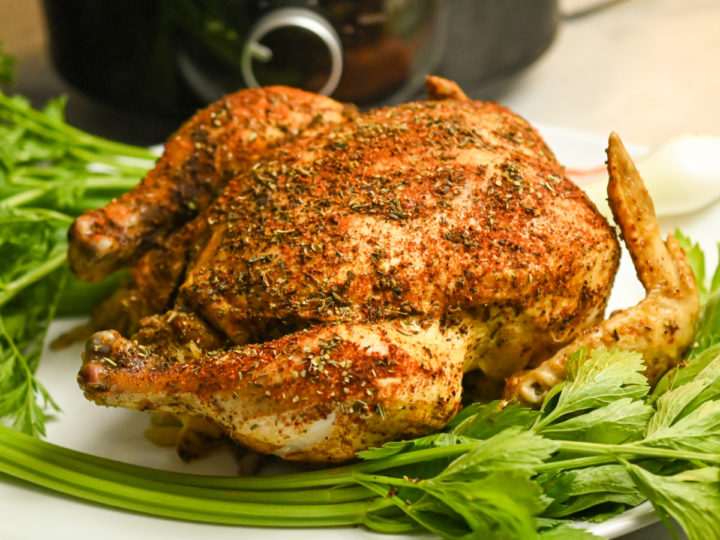 whole keto chicken cooked in a crockpot plated on a white platter