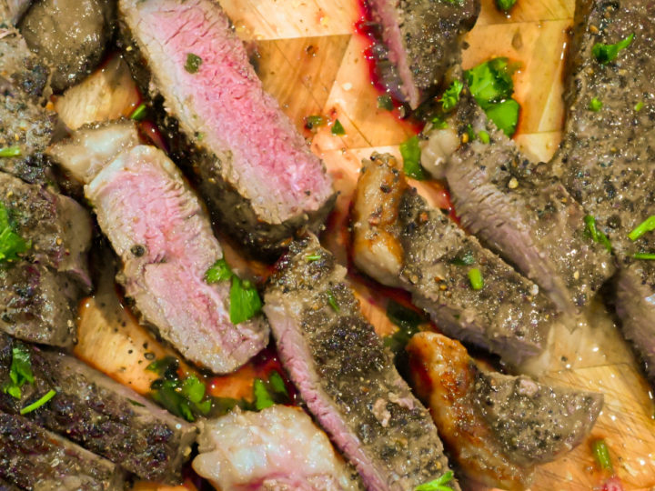 ribeye steaks sliced on a wooden board