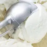 keto coconut ice cream being scooped from an ice cream maker