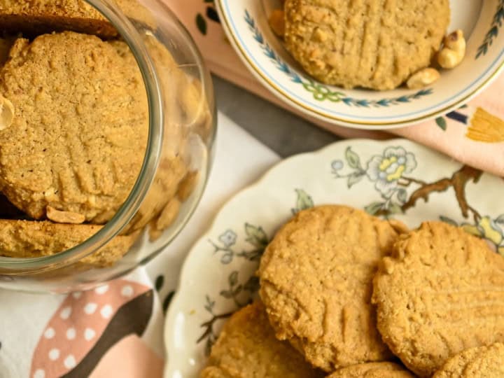 keto Almond flour peanut butter cookies displayed in different size plates and inside a clear cookie jar