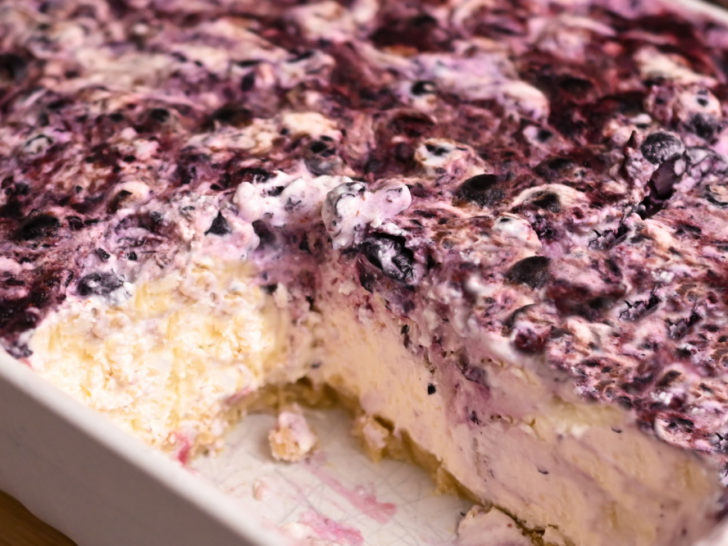 Keto blueberry no bake cheesecake with a couple of slices missing from a 13x9 dish