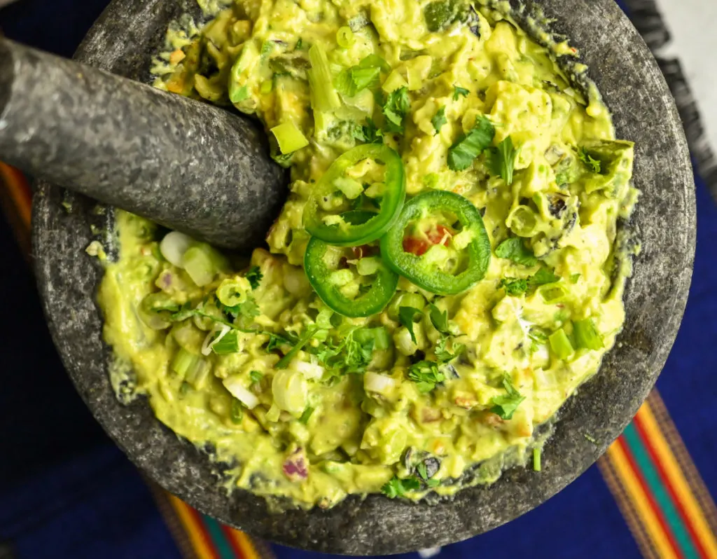 Spicy Guacamole Recipe made and served in a large mortar and pestle