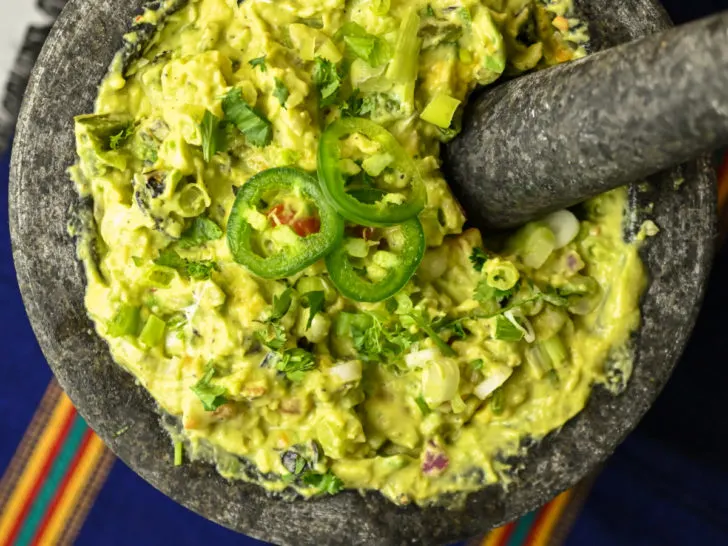 homemade spicy guacamole recipe served in a extra large grey mortar bowl