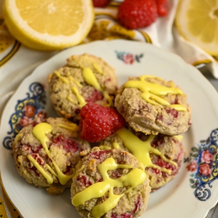Keto Raspberry Lemonade Cookies served in a small plate with fresh raspberries and lemons as garnish