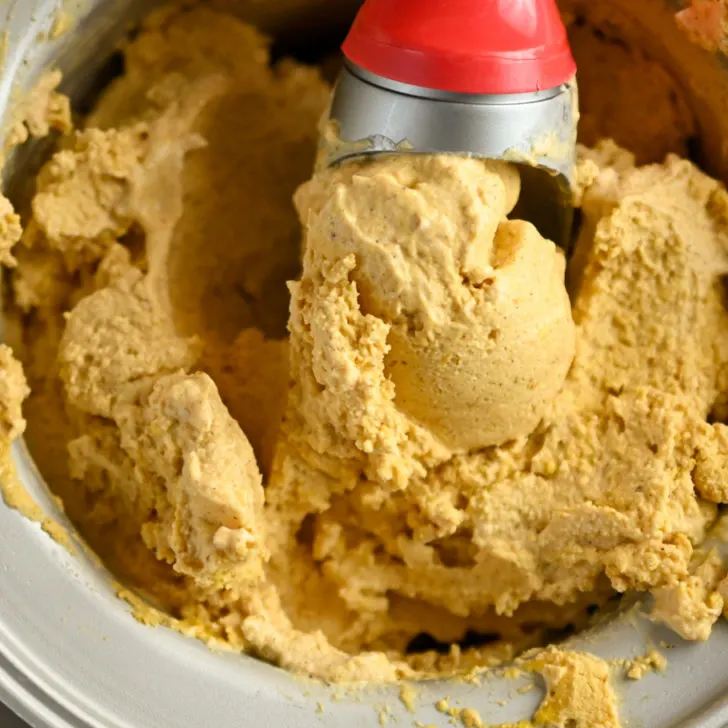 low carb pumpkin ice cream being scooped out of an ice cream maker