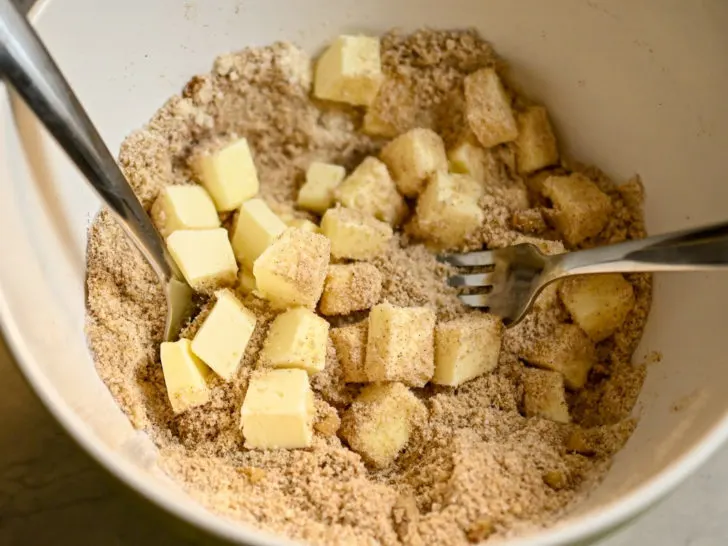 Keto-friendly walnut streusel topping being made in a white bowl
