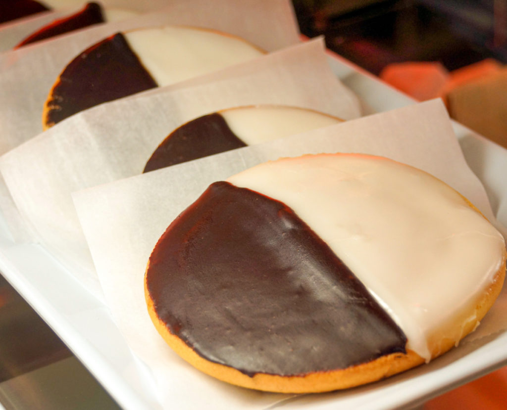 keto black and white cookies separated by parchment paper pieces