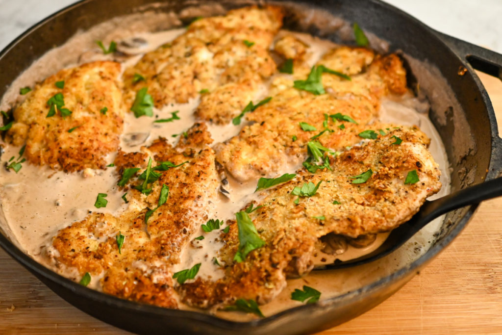 Keto chicken marsala made and served in a large cast-iron skillet