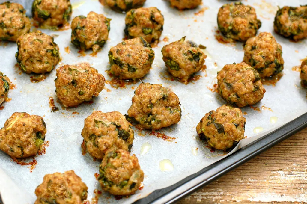 baked keto pastrami meatballs on parchment lined baking sheet