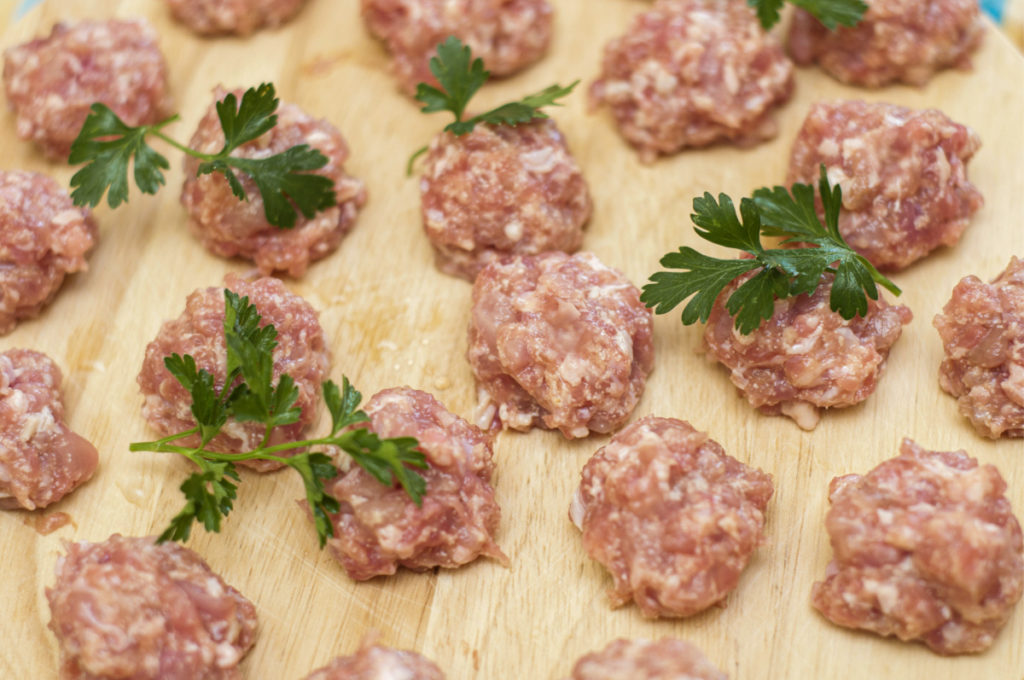 raw meatballs on a wooden board