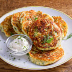 Gluten-free cauliflower fritters plated with a side of ranch dressing