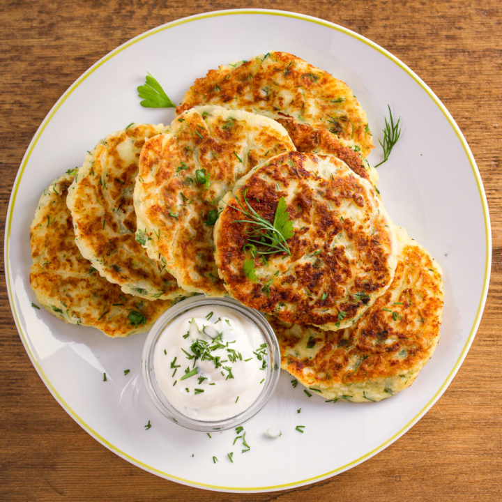 keto cauliflower fritters on a white plate with a side of ranch dressing