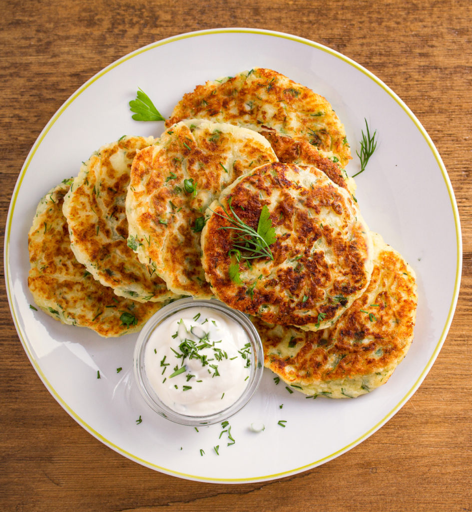 keto cauliflower fritters on a white plate with a side of ranch dressing