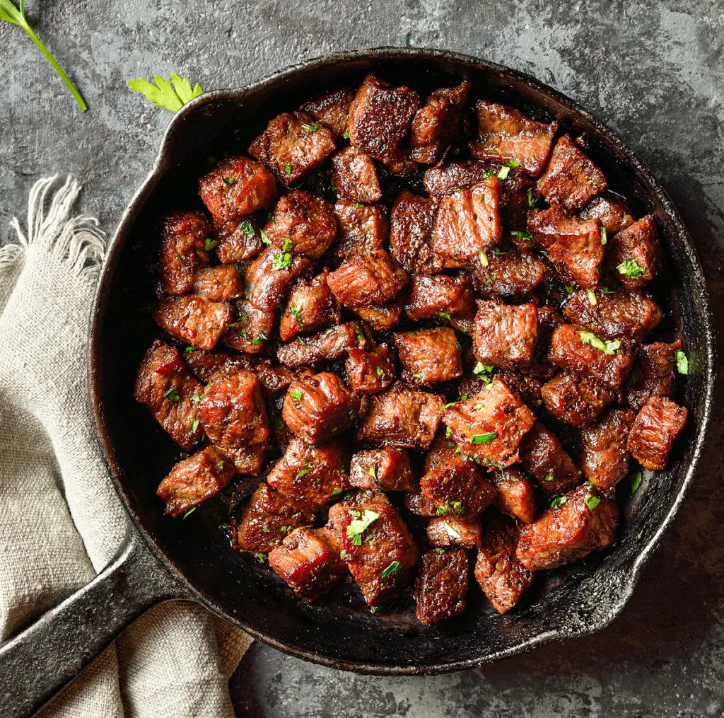 keto garlic butter steak bites cooked in a cast iron skillet