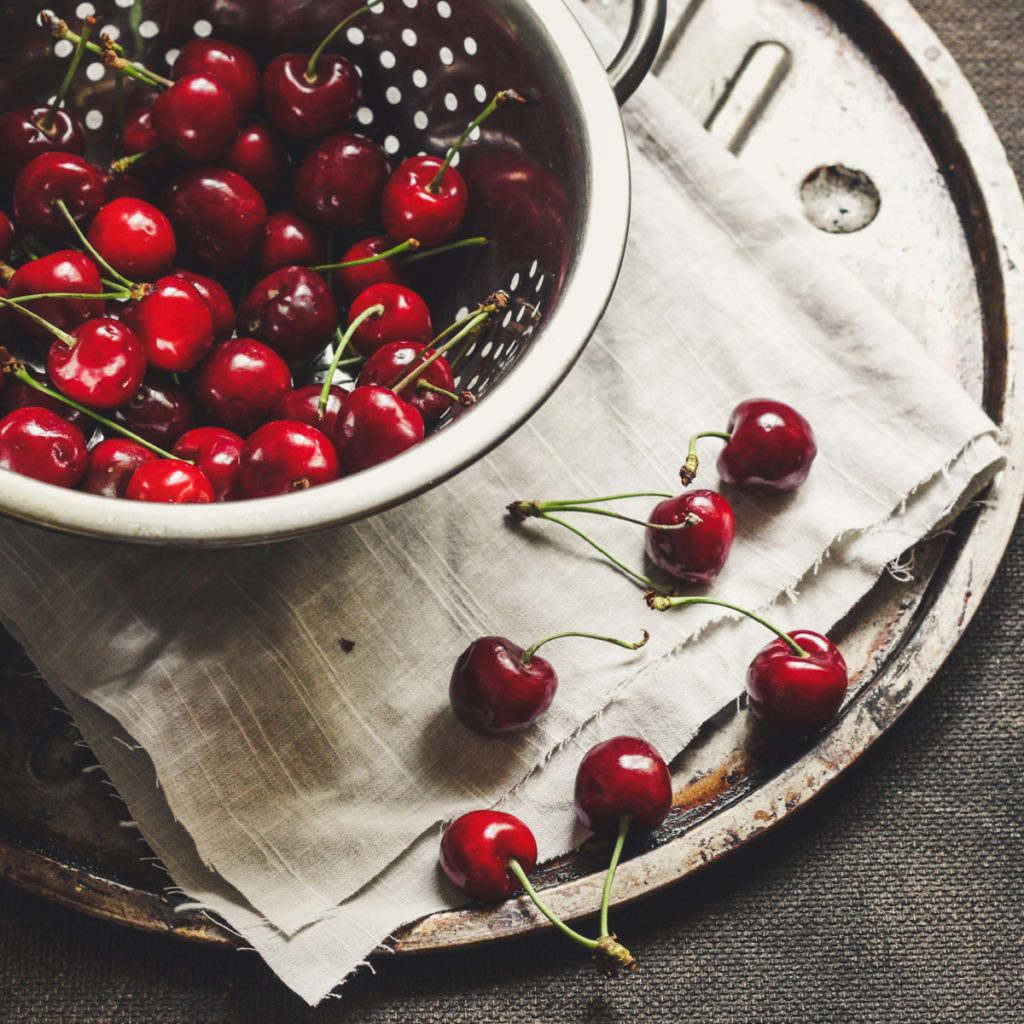 fresh cherries in a colander bowl