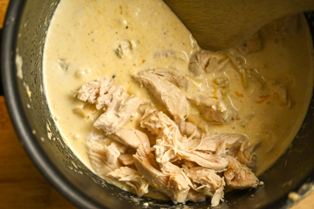 Rotisserie chicken being added to cheese sauce