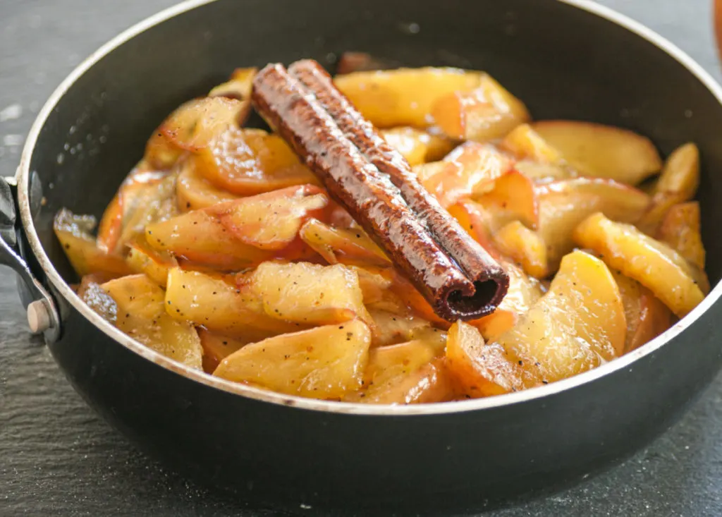 chayote squash cooked as apples in a skillet pan.
