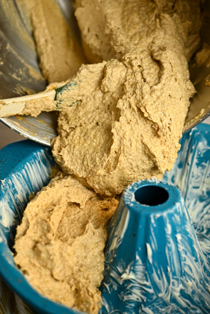 Keto banana cake batter being added to a bundt pan for baking