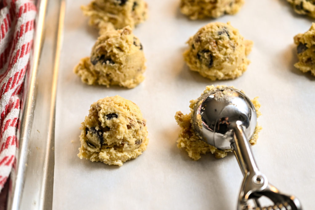 Keto chocolate chip pecan cookie dough being added to cookie sheet