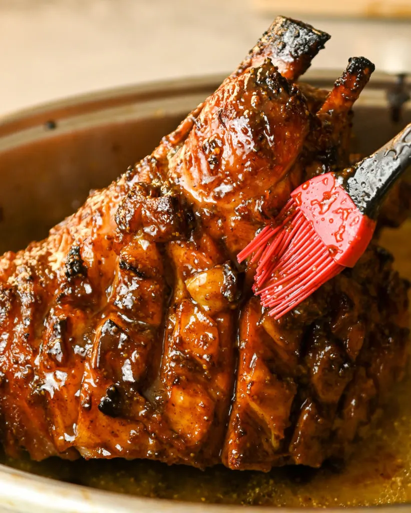 ham being basted with a keto-friendly sweet mustard glaze