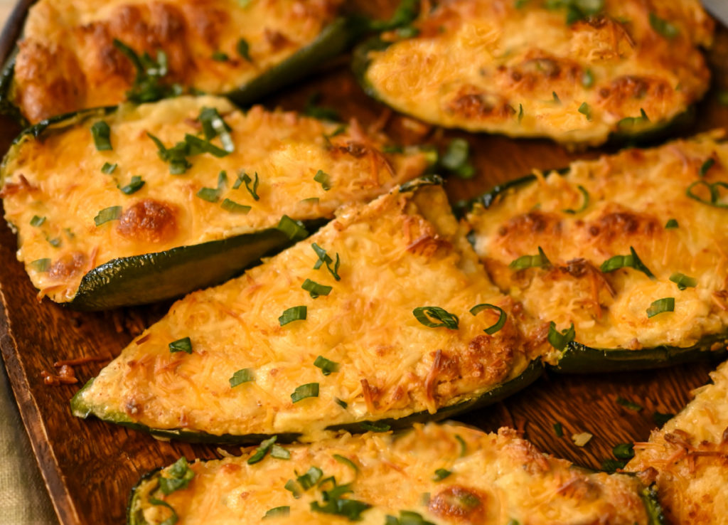 keto chicken cheese stuffed poblano peppers served on a wooden board