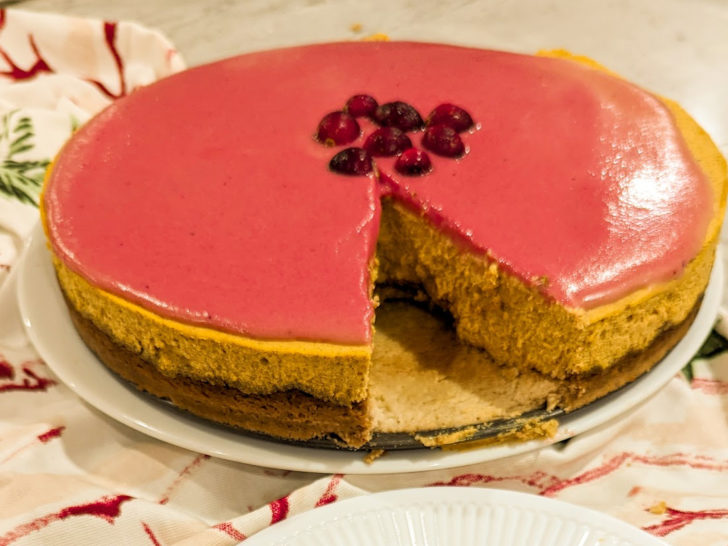 keto cranberry curd pumpkin cheesecake with a slice missing