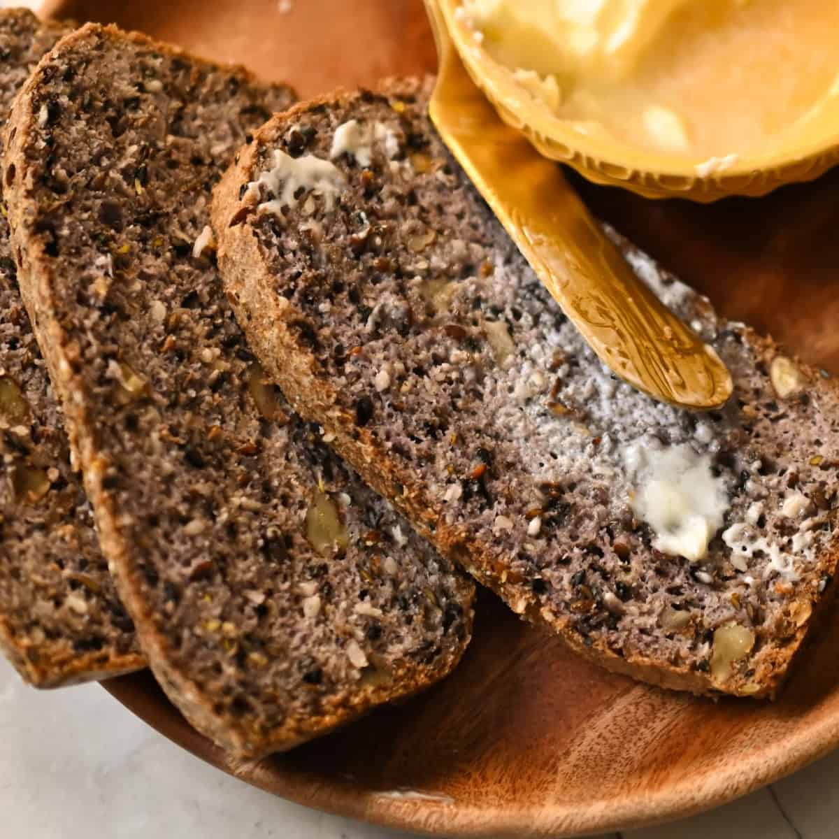 three keto high fiber bread slices with butter on a wooden plate1200