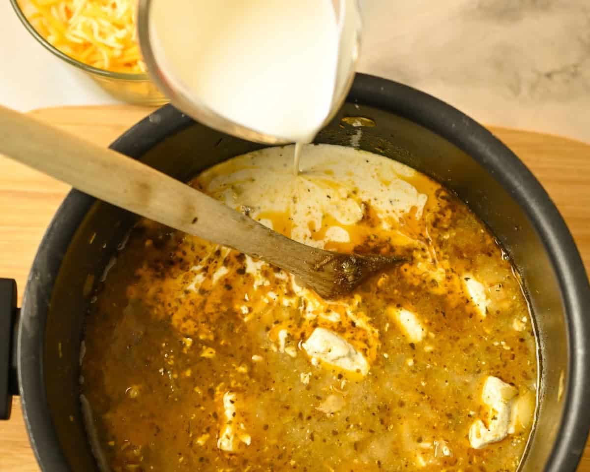 carnivore creamy chicken soup with ingredients being added