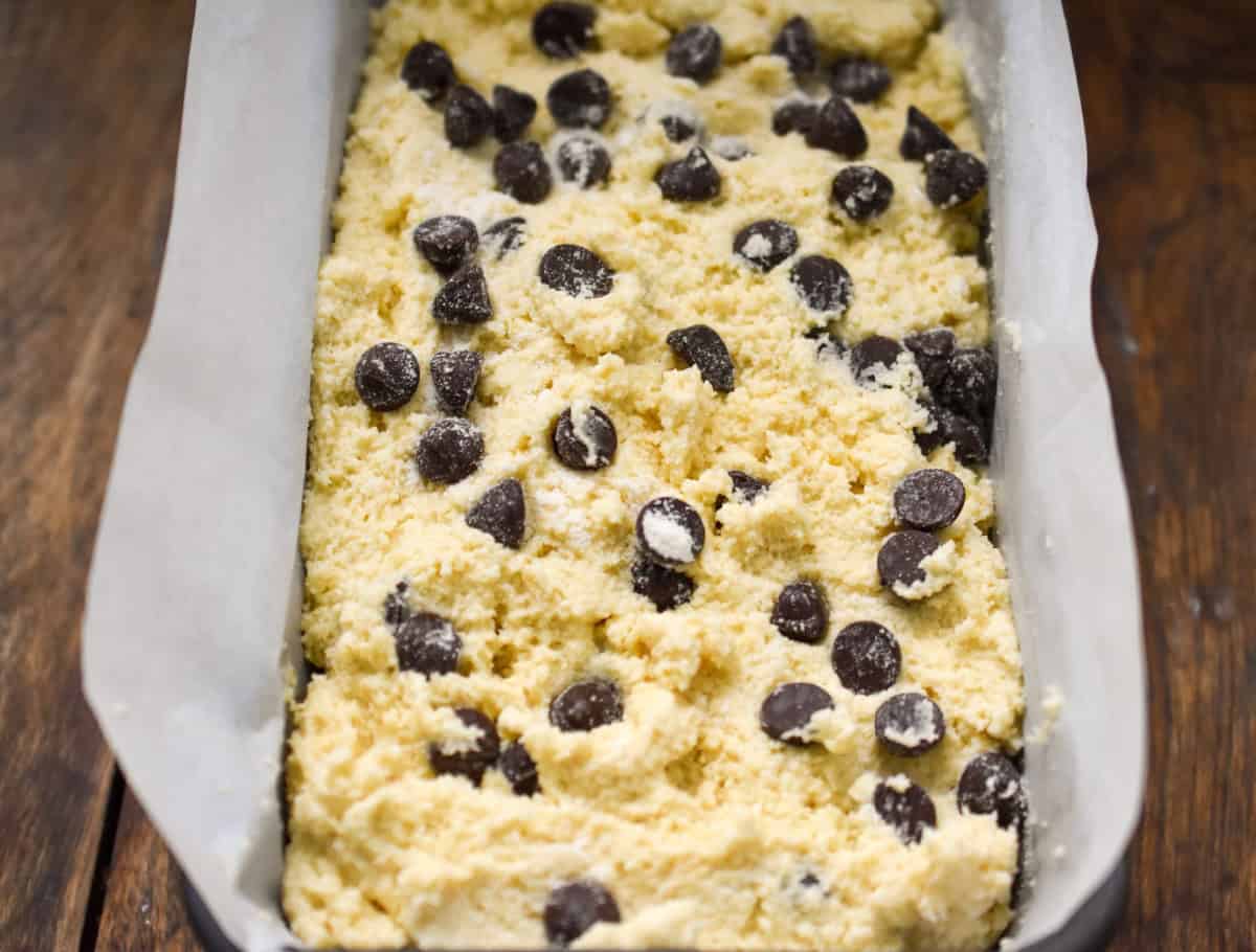 keto coconut flour chocolate chip pound cake batter inside a parchment lined loaf pan