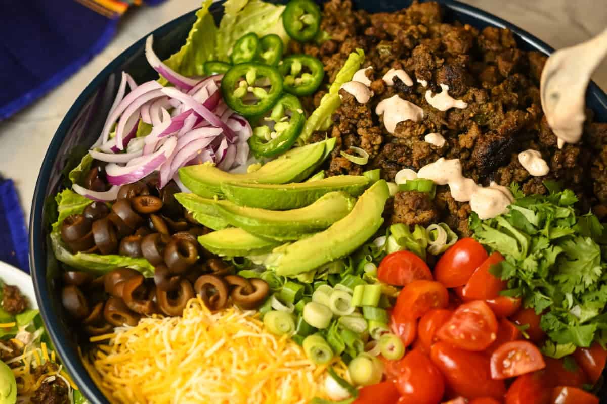 Creamy salsa being added to the ground turkey keto salad