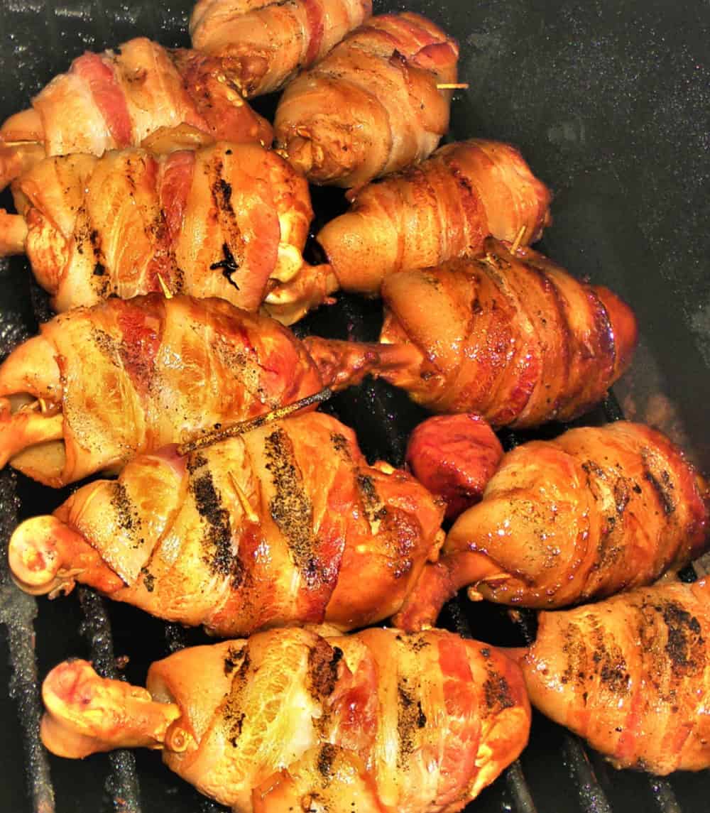 carnivore bacon-wrapped chicken drumsticks cooked on a grill