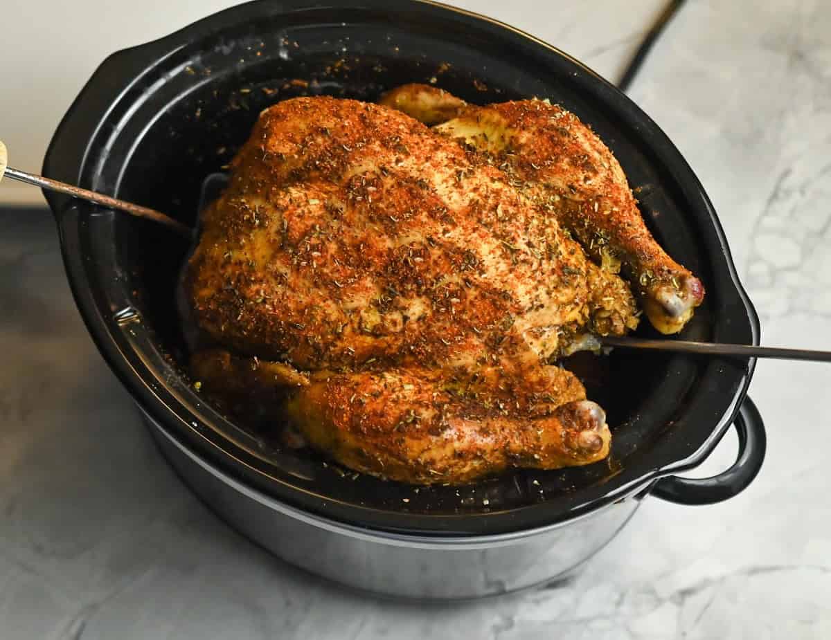 carnivore crockpot whole chicken being taken out of the crockpot